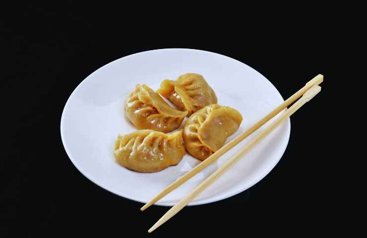 ravioli in un piatto e bacchette cinesi